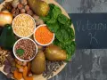 En bricka med mat rik på vitamin K1: spenat, päron, avokado, nötter, linser, bönor, torkade aprikoser, solrosfrön och choklad.