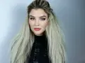 En kvinna med blå ögon och en snygg makeup har sitt blonda hår stylat med en våffla.