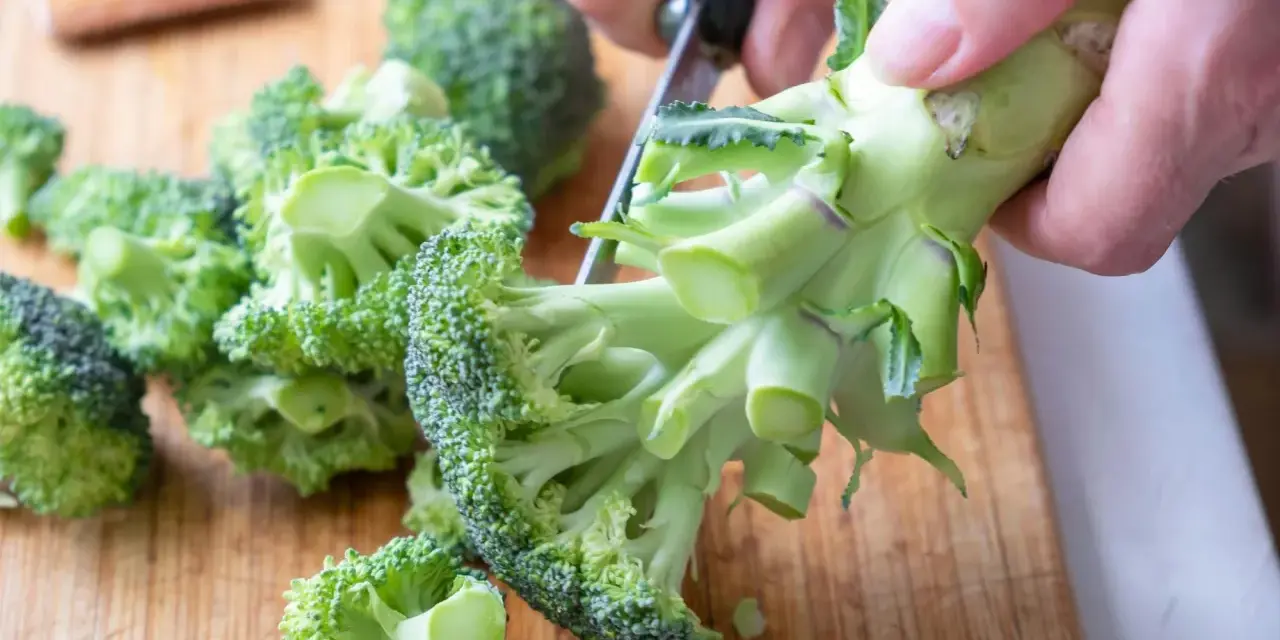 Färska broccolibuketter på en skärbräda, redo att tillagas för att bevara alla nyttiga vitaminer.