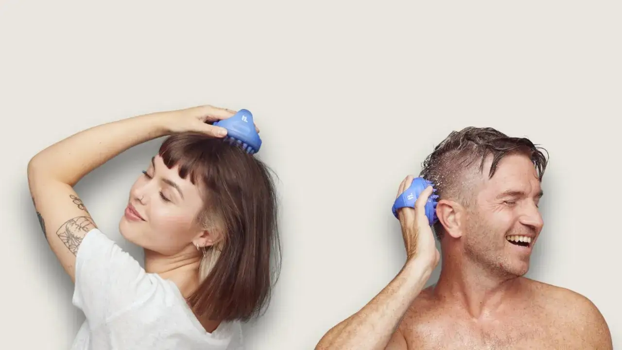 En kvinna och en man njuter av en avslappnande hår massage med blåa borstar.